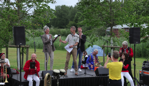 Het bestuur bij het feest op 2 juni. Links op het podium, staand is Willemieke de Waal. In het midden Toon Weijenborg en rechts Pascal de Gouy. Het bestuur bij het feest op 2 juni. Links op het podium, staand is Willemieke de Waal. In het midden Toon Weijenborg en rechts Pascal de Gouy.