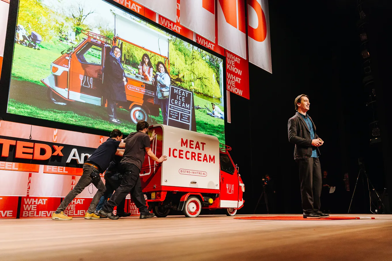 Koert van Mensvoort on stage at TEDx, next to a van with the text Meat Ice Cream