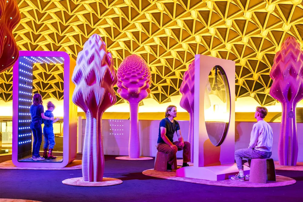Visitors among colourful sculptural trees in Next Nature Museum